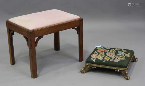 A late Victorian carved giltwood footstool, on carved scroll...