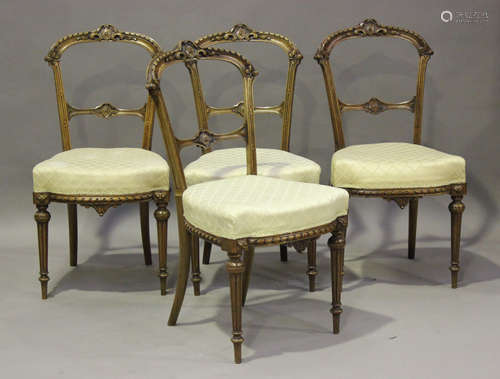 A set of four late Victorian walnut dining chairs with carve...