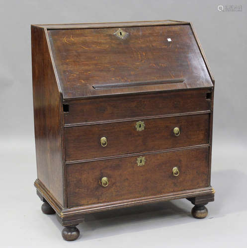 An early 18th century oak bureau, the fall-front revealing a...