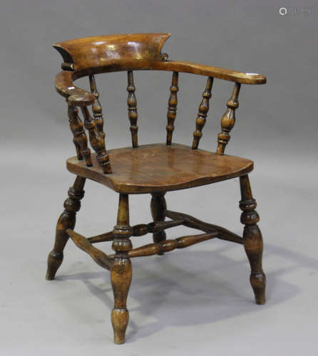 A late Victorian beech and elm captain's armchair, the solid...
