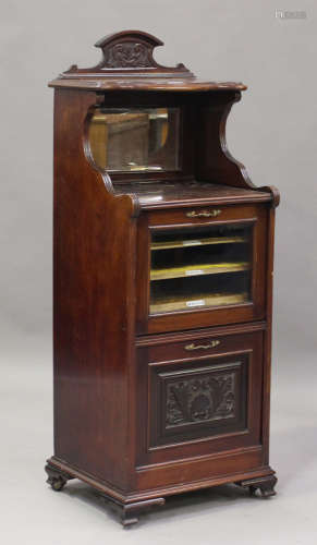 A late Victorian mahogany music cabinet with carved decorati...