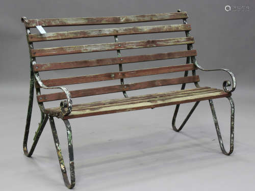 A 20th century wrought iron and wooden slatted garden bench ...