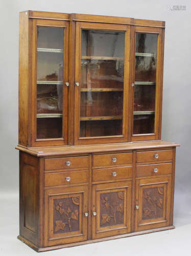 An Edwardian oak breakfront bookcase, the glazed top above c...