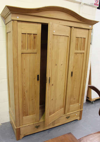 An early 20th century Continental pine armoire, the arched t...