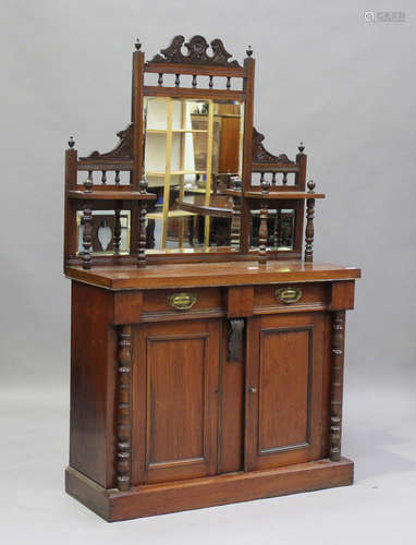 A late Victorian walnut chiffonier, the mirror back above tw...