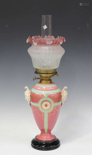 A late 19th century ceramic table oil lamp with a frosted gl...