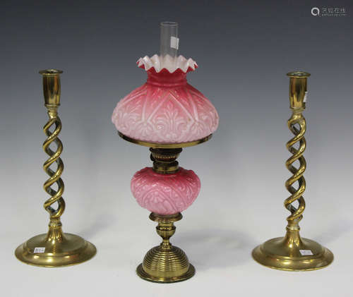 A late Victorian gilt brass and pink glass table oil lamp of...