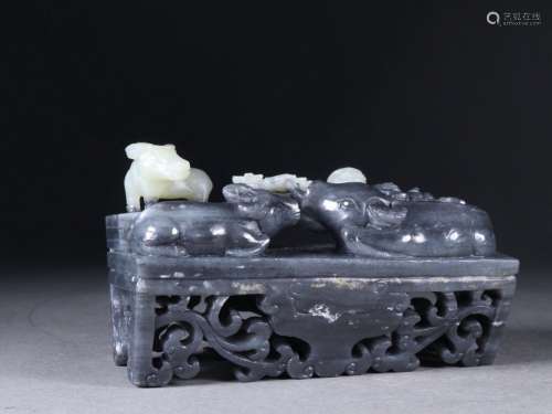 A QING DYNASTUY HETIAN JADE BLUE AND WHITE PEBBLE CATTLE ORN...