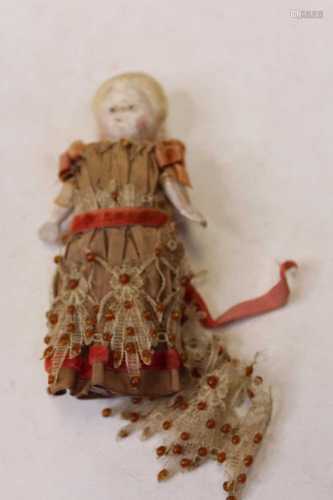 A late 19th century pumpkin head doll, having a waxy composi...