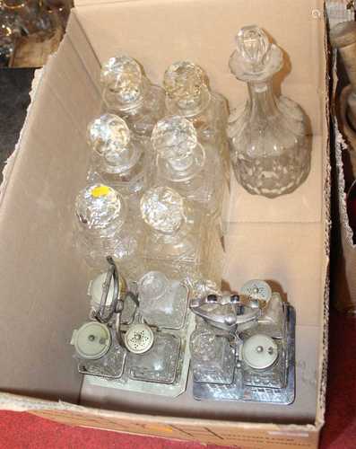 A box containing a collection of cut glass decanters and tab...