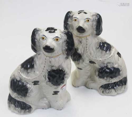 A pair of reproduction Staffordshire figures of seated spani...