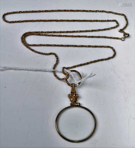 A gilt metal magnifying glass on neck chain