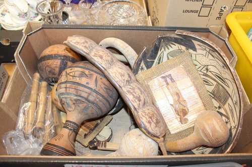 A box of African carvings to include carved nuts, a carved b...