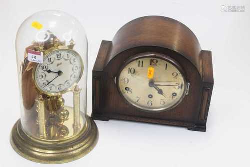 A 1950s oak cased mantel clock, having a silvered dial with ...