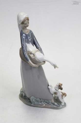 A Lladro Spanish porcelain figure of a girl holding a goose ...