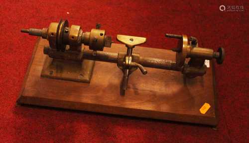 A vintage brass lathe mounted on a teak stand, 40cm wide ove...