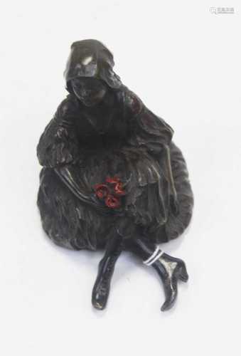 A reproduction bronzed model of a young girl, in seated pose...