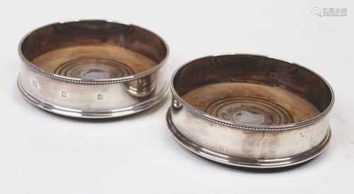 A pair of modern silver bottle coasters, each having a beade...