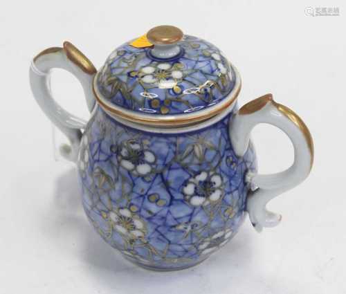 A 20th century twin handled jar and cover, on a blue broken-...