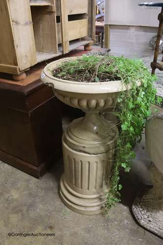 A Victorian buff-glazed stoneware garden urn on fluted pedes...