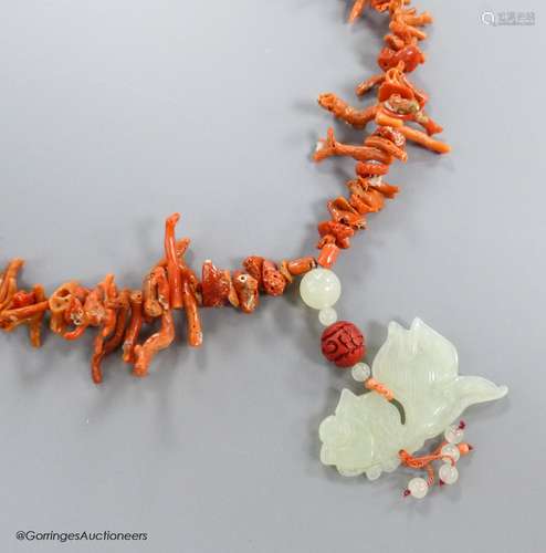 A jagged coral bead necklace, with jade pendant, carved as a...