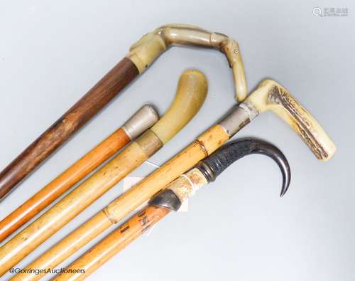 Five various walking sticks: three horn-handled, one silver-...