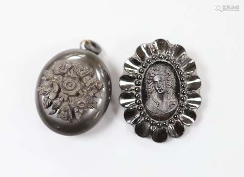 A jet oval pendant, carved with a bunch of flowers, 41mm and...