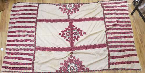 A silk embroidered Suzani, embroidered with cherry red flowe...