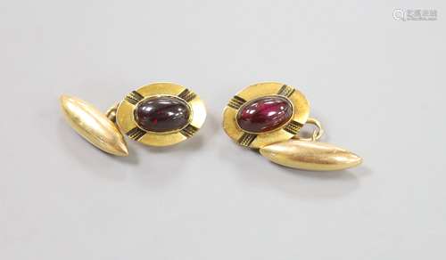 A pair of yellow metal and cabochon garnet set oval cufflink...