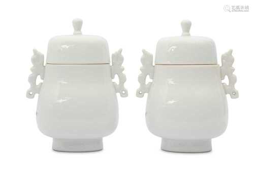 A PAIR OF CHINESE WHITE-GLAZED ARCHAISTIC VASES AND COVERS.