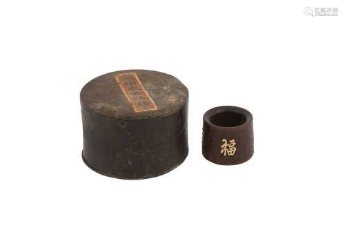 A CHINESE INSCRIBED AND GOLD-INSET AGARWOOD ARCHER'S RING.