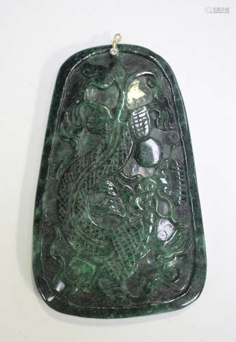 A Chinese green hardstone pendant, 20th century, one side ca...