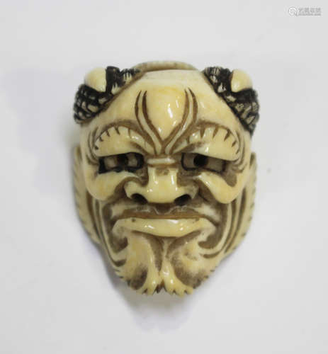 A Japanese carved ivory two-faced Noh mask netsuke, Meiji pe...