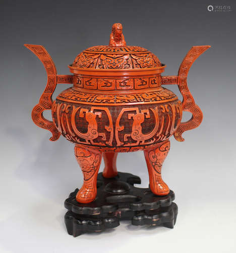 A Chinese cinnabar style covered metal tripod censer and cov...