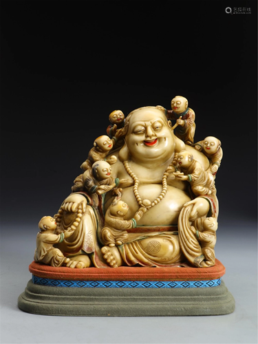 A SOAPSTONE CARVING OF MAITREYA WITH CHILDREN