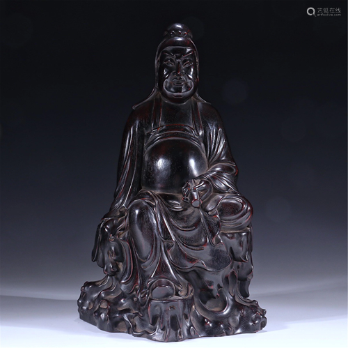 A HARDWOOD CARVED SEATED FIGURINE