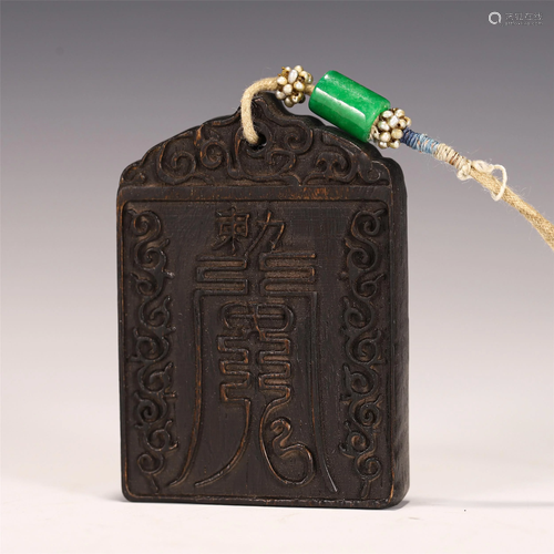 A CARVED CHENXIANG WOOD TOKEN PENDANT