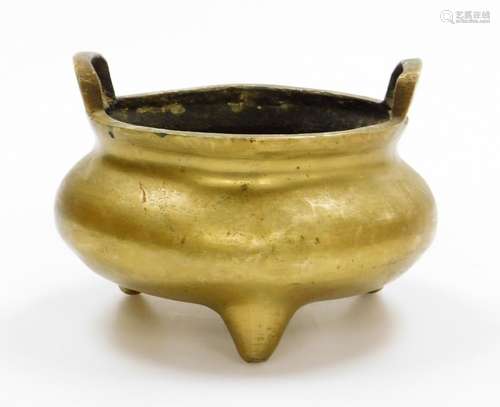 A Chinese bronze tripod censer, with two loop handles, cast ...