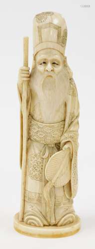 A Japanese ivory okimono of the God Jurojin holding a staff ...