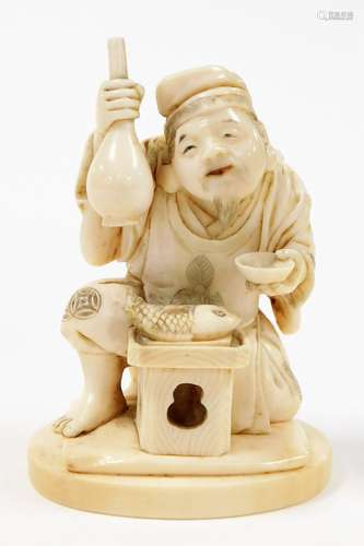 A Japanese ivory okimono of the God Ebisu, holding a sake bo...