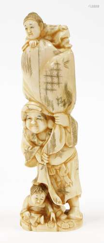 A large Japanese carved marine ivory okimono, of man with tw...