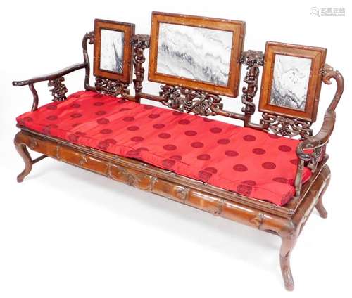 A Chinese hardwood three seater sofa, carved in imitation ba...