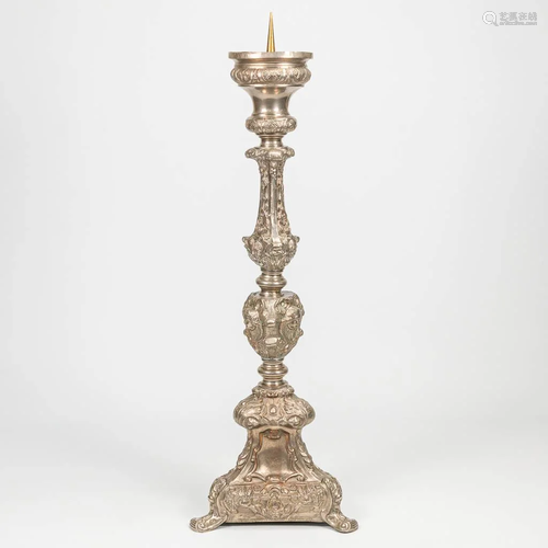 A large candlestick made of silver plated copper. The