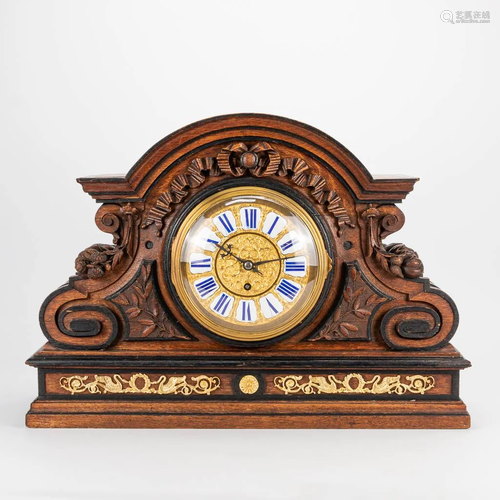 A large sculptured clock made of wood mounted with