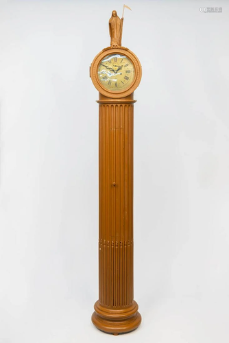 A large standing clock in the shape of a pillar and