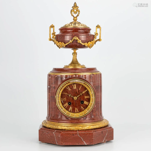 A clock made of red marble and mounted with ormolu