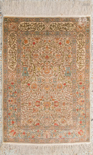 An Oriental hand-made carpet made of silk and signed.