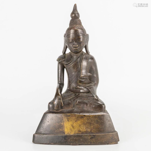 An antique Oriental Buddha, made of patinated bronze.