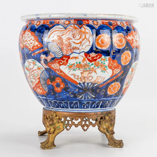 An Imari porcelain vase standing on a bronze base.