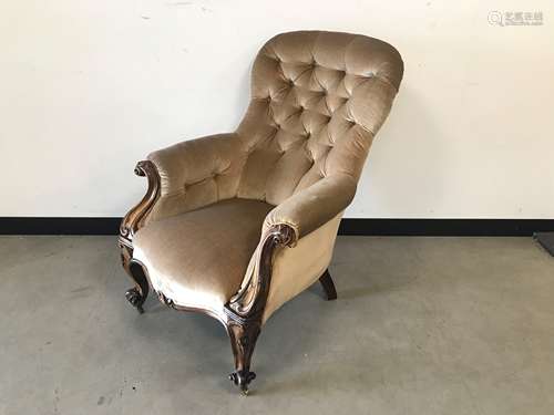 A Victorian walnut framed spoon back buttoned armchair, the ...